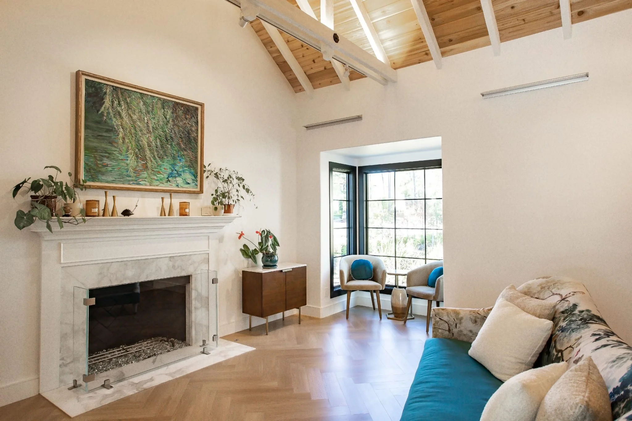 Bright living room with exposed wood ceiling beams and tall windows