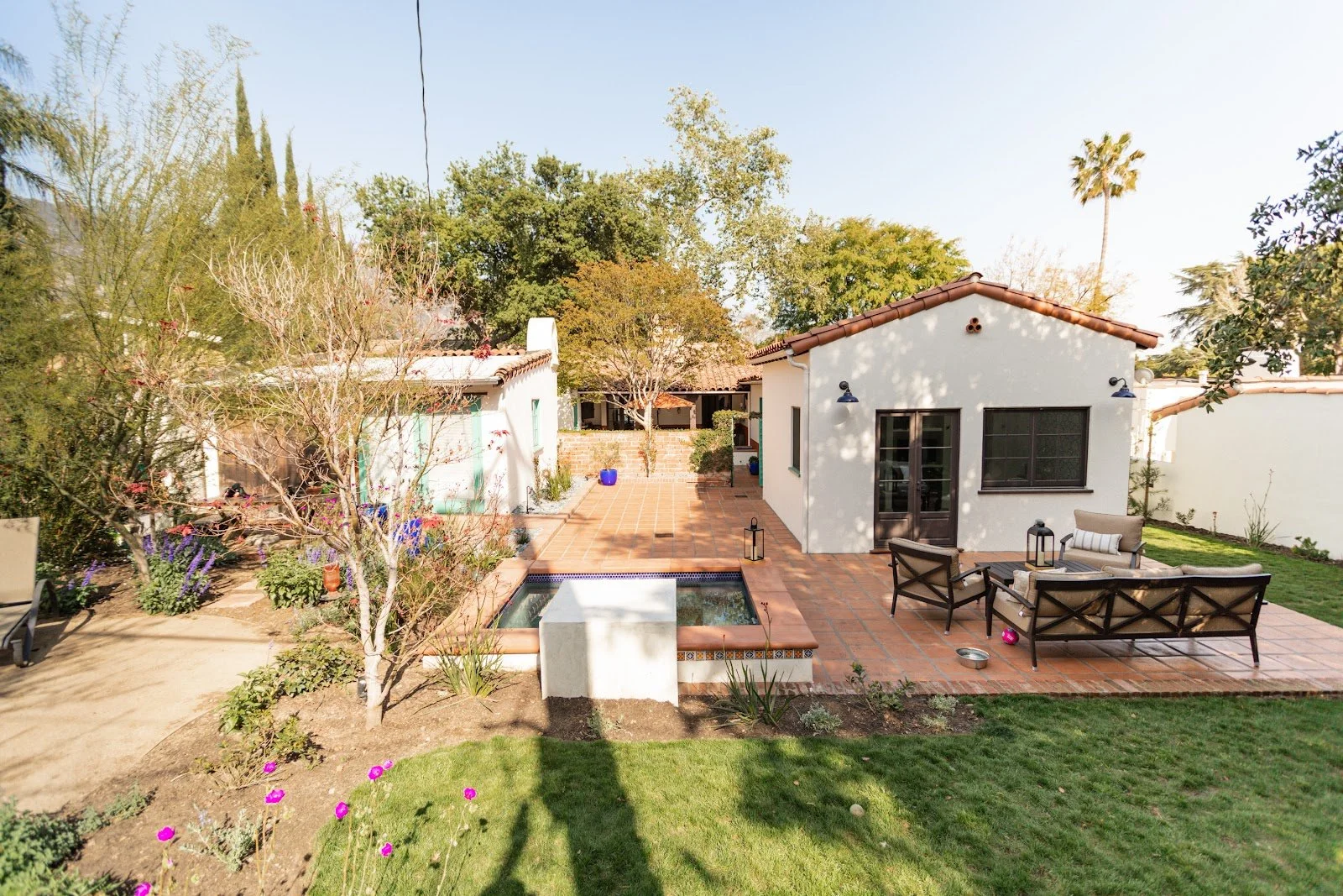 Mom’s Sanctuary courtyard with a tiled spa, fountain and Spanish-style addition