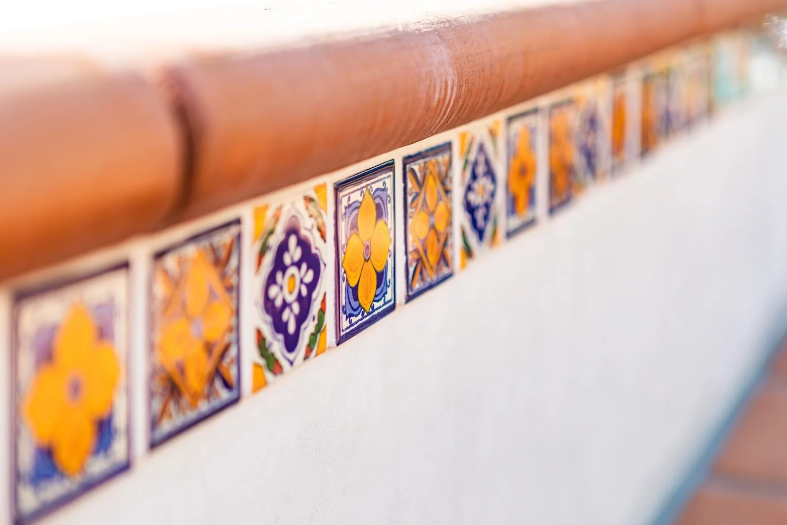 Colorful Spanish tiles beneath terracotta coping