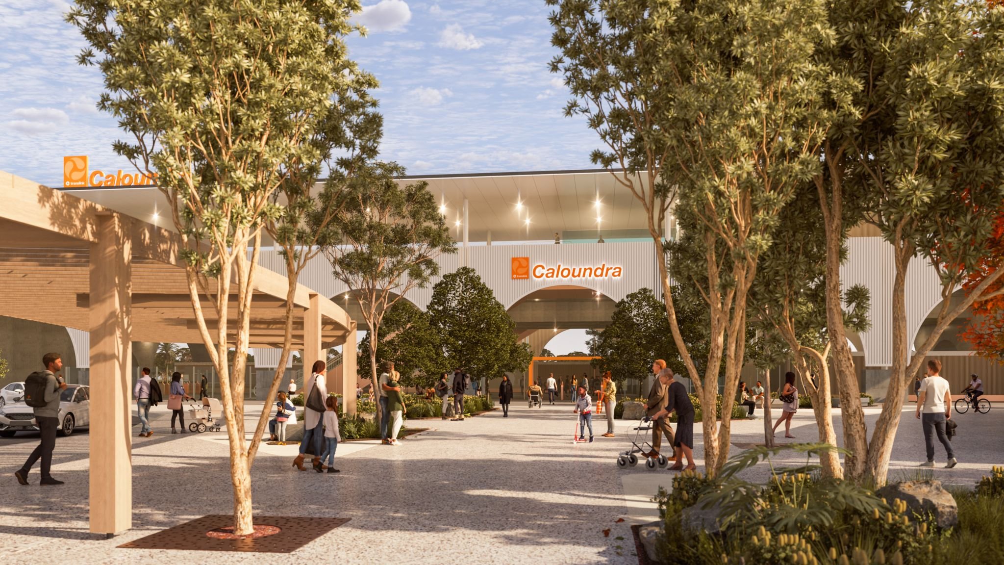 A modern outdoor shopping center with trees, people walking, some pushing strollers, and storefronts with "Caloundra" signs.