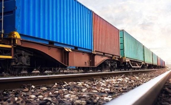 Cargo train with colorful containers moving on railway tracks.