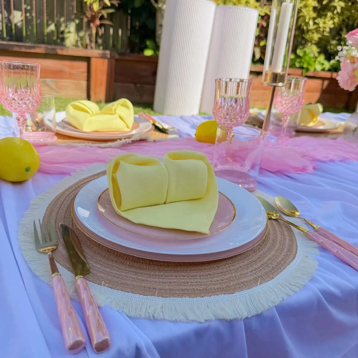 Luxury picnic place setting with yellow napkin and pink plates