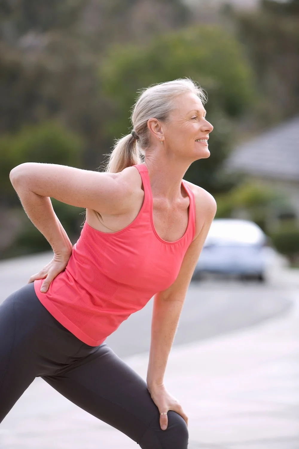 Older woman stretching outdoors, representing movement support and mobility after surgery or injury.