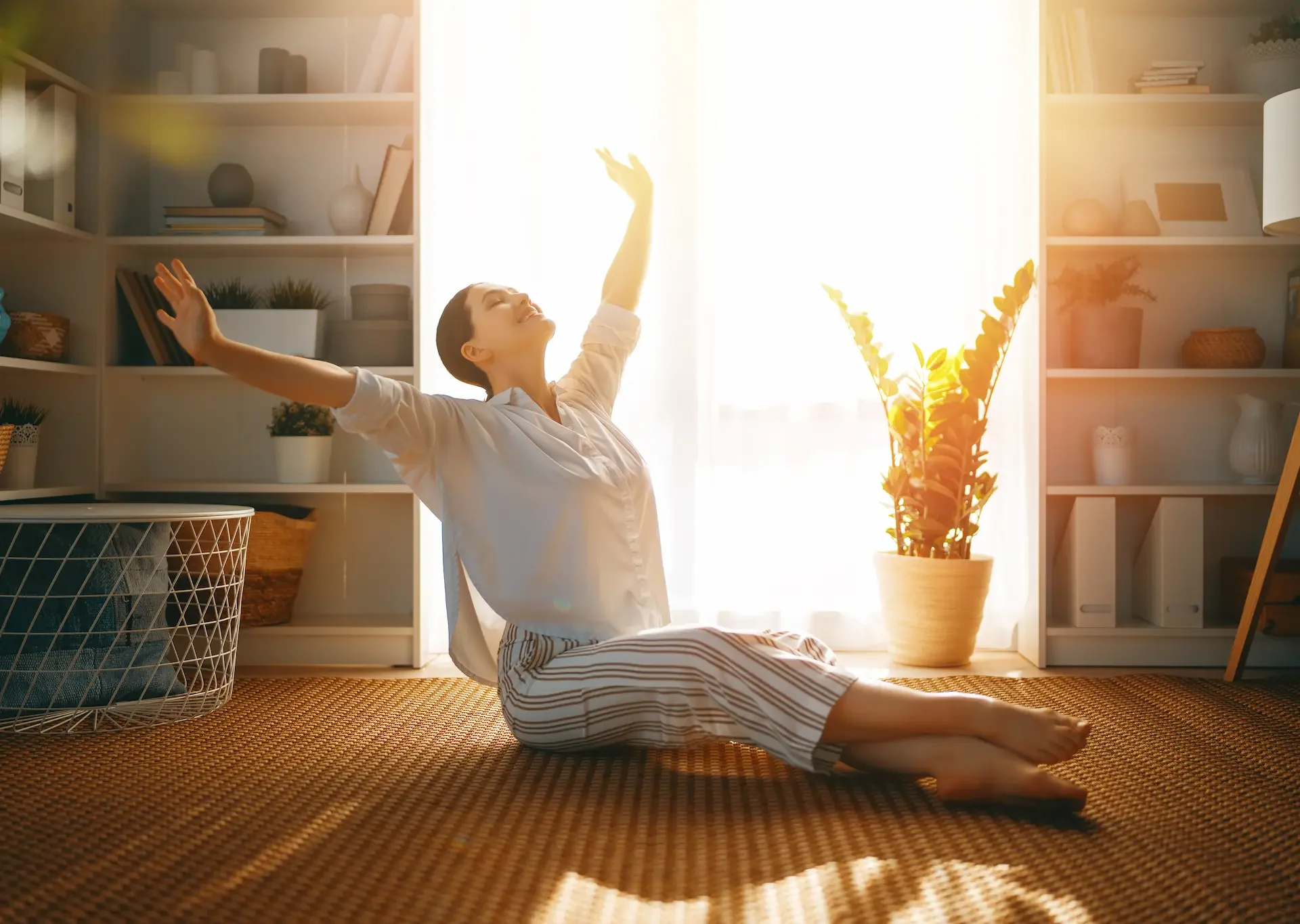 Woman gently stretching her side in soft morning light at home