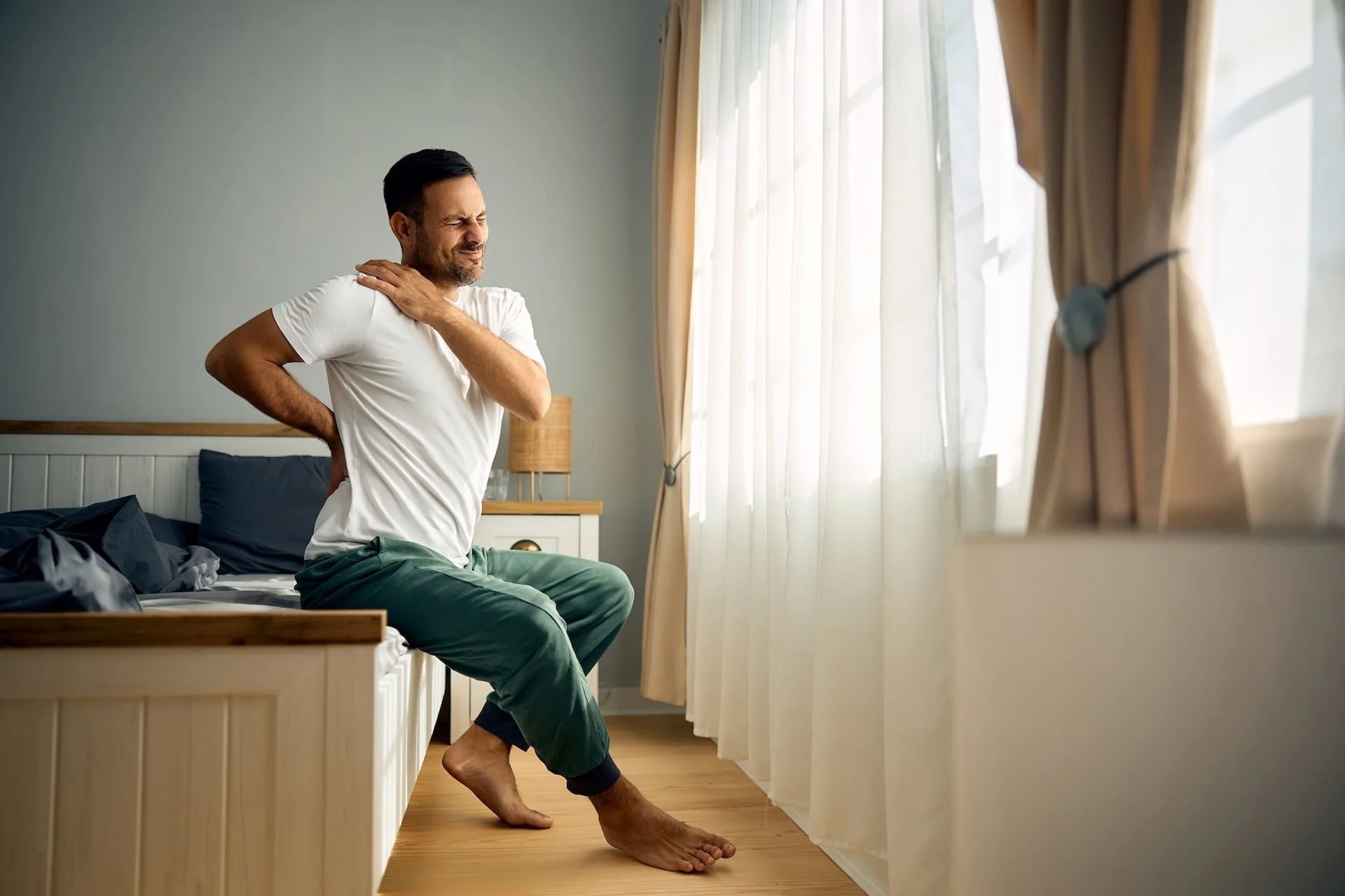 Person waking up with morning stiffness in the back, neck or shoulders