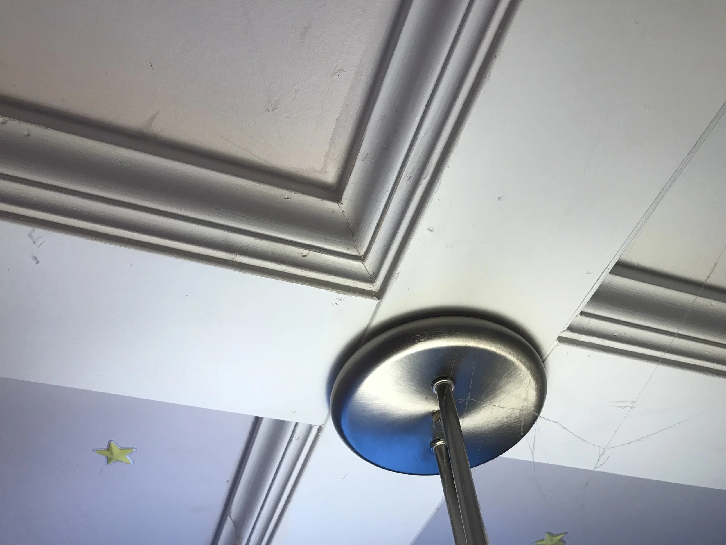 Close-up view of a metallic door hinge with a door latch and a door stopper visible.