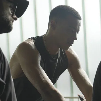A young man exercising, sweating, in a gym or fitness center.