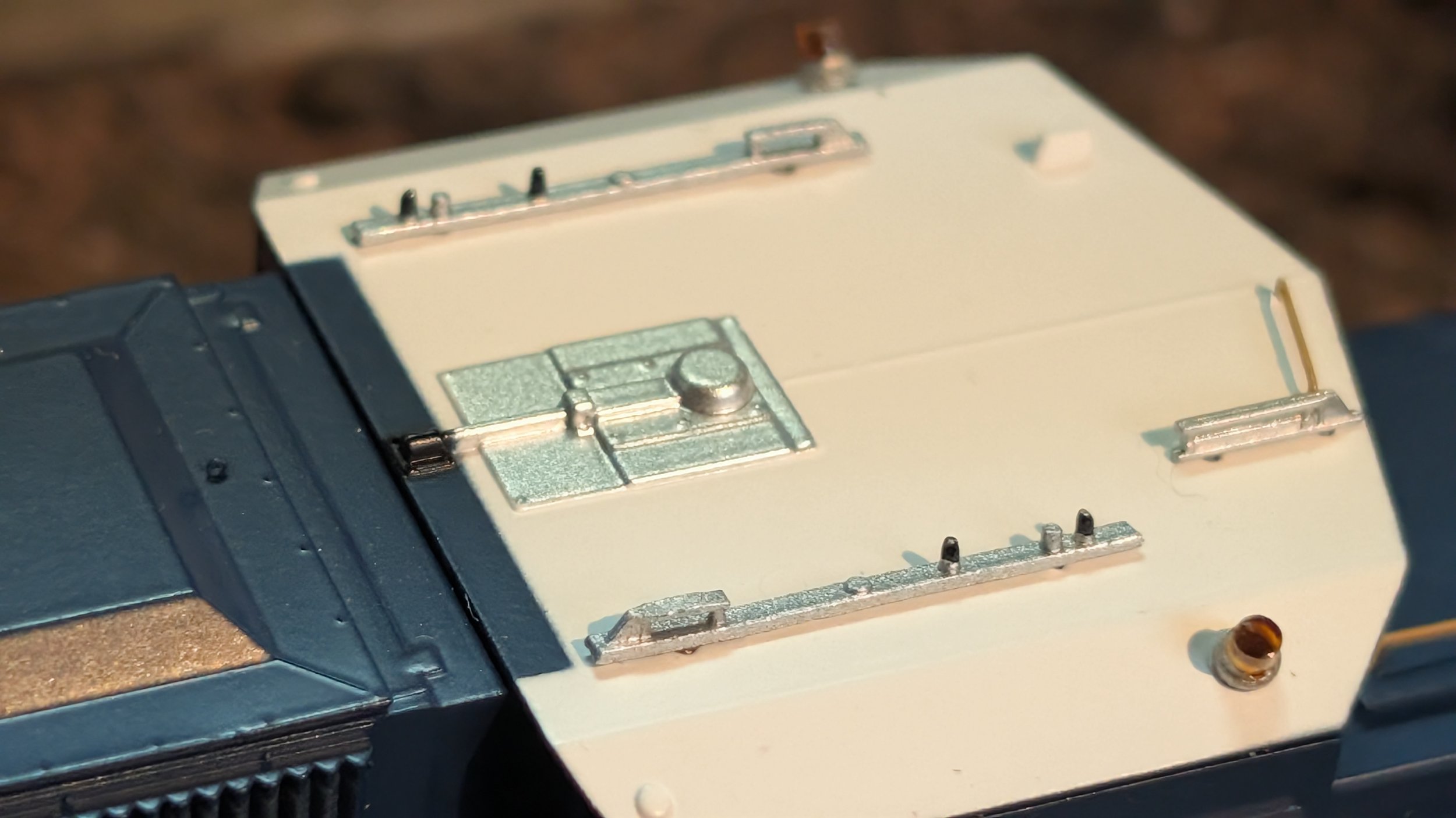 A close-up of an electronic device or component with metal and plastic parts, possibly part of a circuit or mechanical assembly.