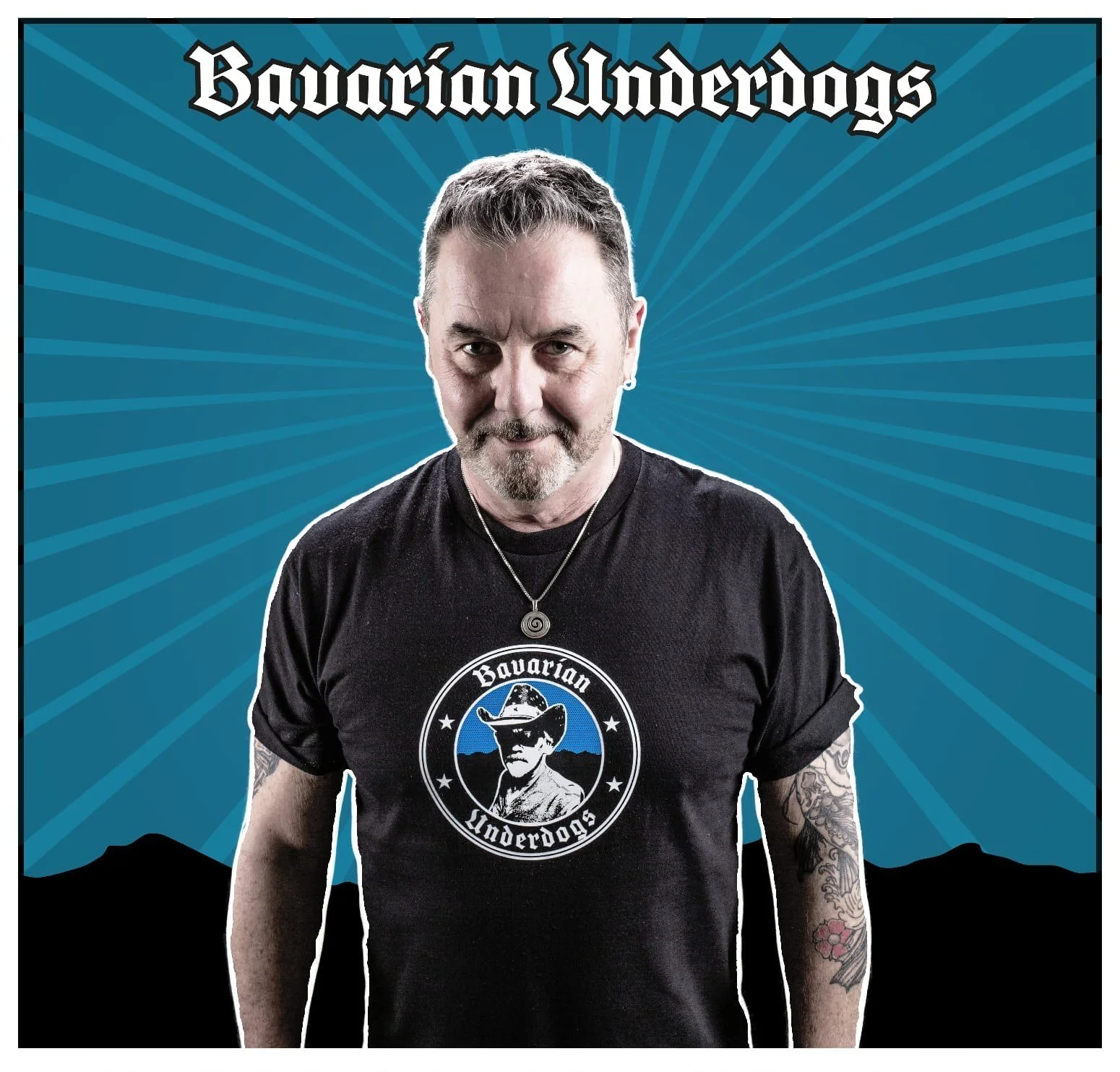 Porträt eines Mannes mit Tattoo, schwarzem T-Shirt mit 'Bavarian Underdogs' Logo, im Hintergrund blauer mit Linien gestalteter Himmel