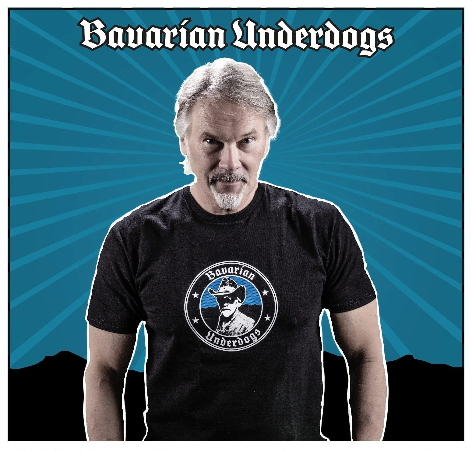 Markus Kleinhans trägt ein schwarzes T-Shirt mit dem Logo der Bavarian Underdogs, einer amerikanischen Footballmannschaft, vor einem blauen Hintergrund mit radialen Linien.