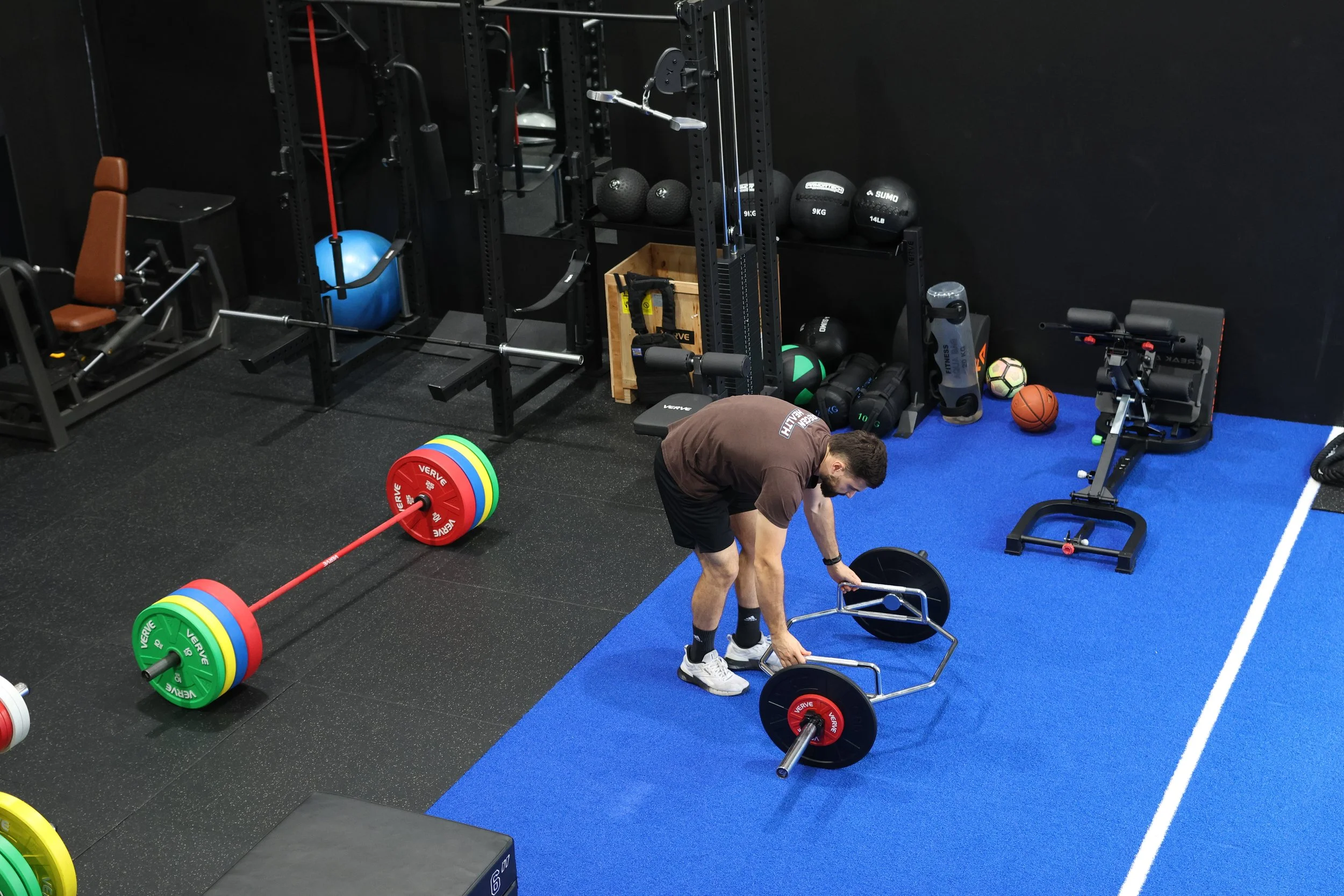 Person stretching with resistance band in a gym.