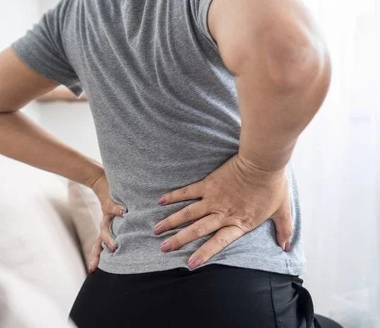 Person holding their lower back due to pain