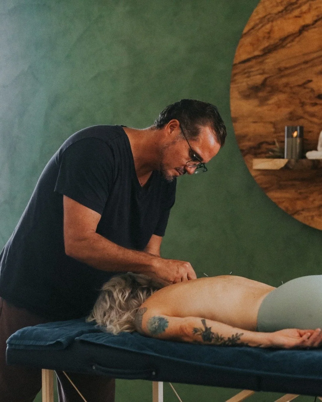 Steven Booth giving Lisa Dominey acupuncture along her back in his Byron Bay treatment room