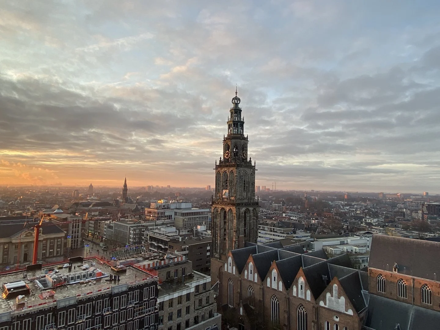 Luchtfoto van de Martinitoren en binnenstad van Groningen bij zonsondergang, foto Johan Bosma