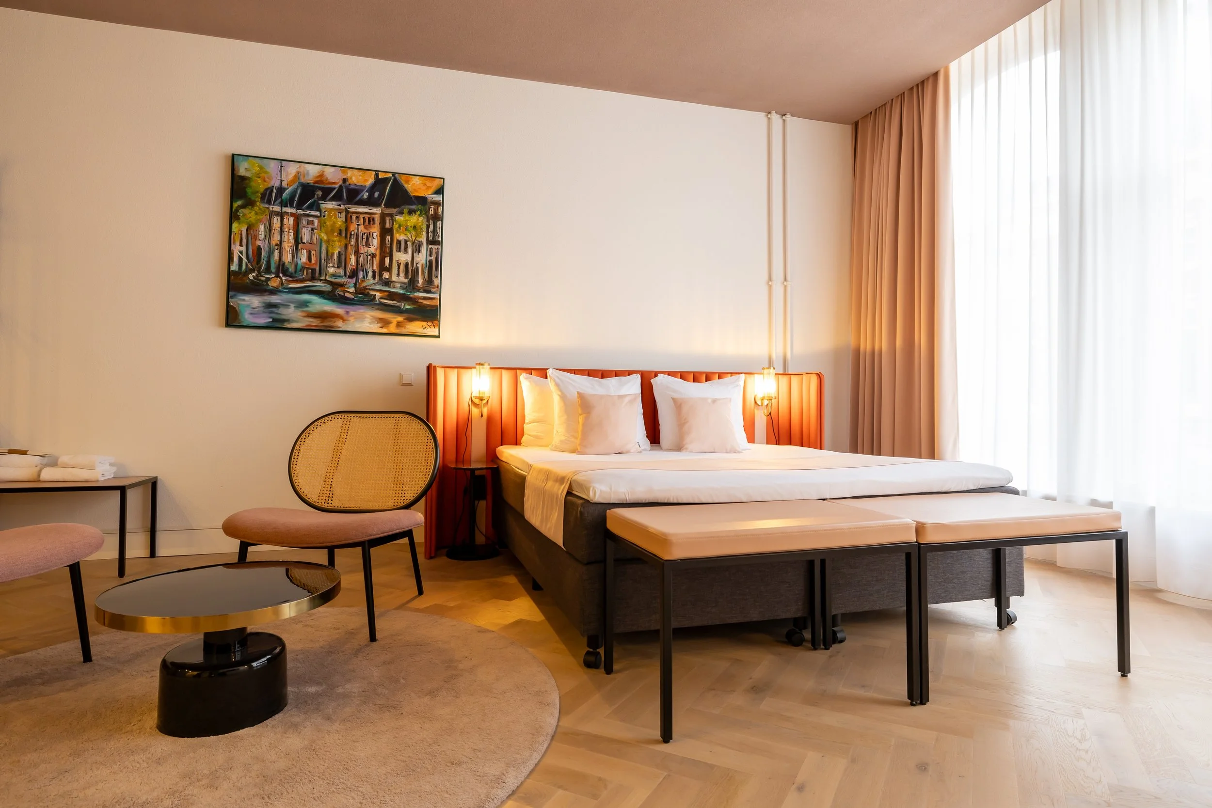 Suite Hotel Halbert Groningen, featuring a double bed, a sitting area, and warm, neutral decor