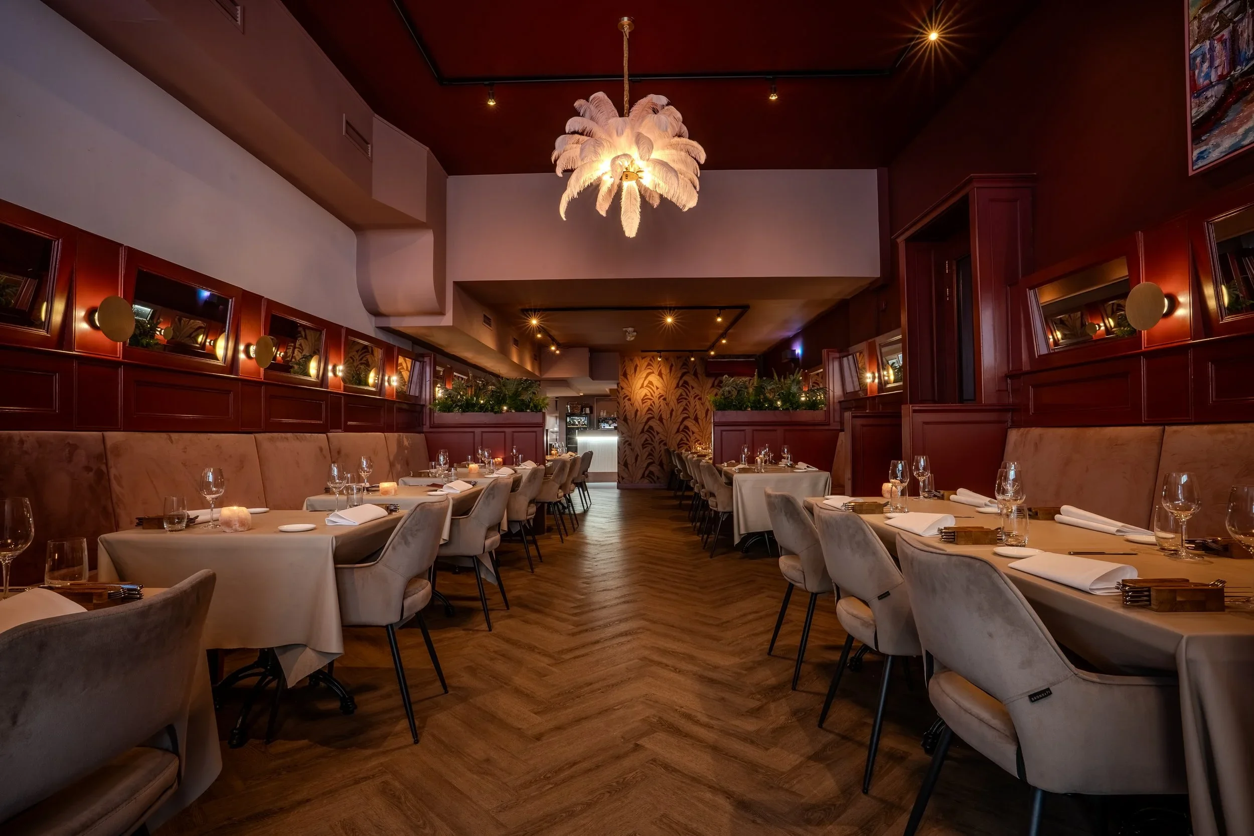 10:12 Interior of Restaurant Blumé in Groningen, featuring set tables, herringbone parquet flooring, and warm red tones