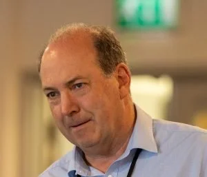 A wearing a light blue shirt appears to be in a professional setting.