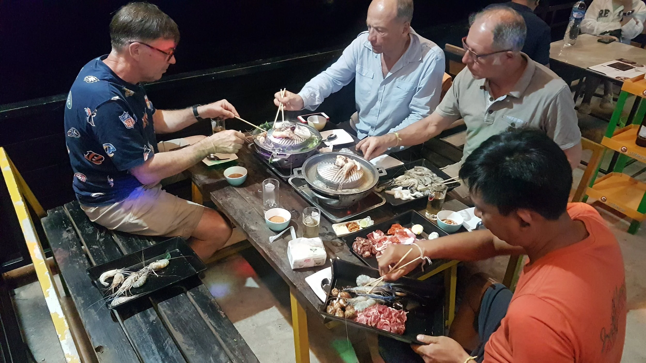 Groupe de personnes mangeant du barbecue de fruits de mer dans un restaurant