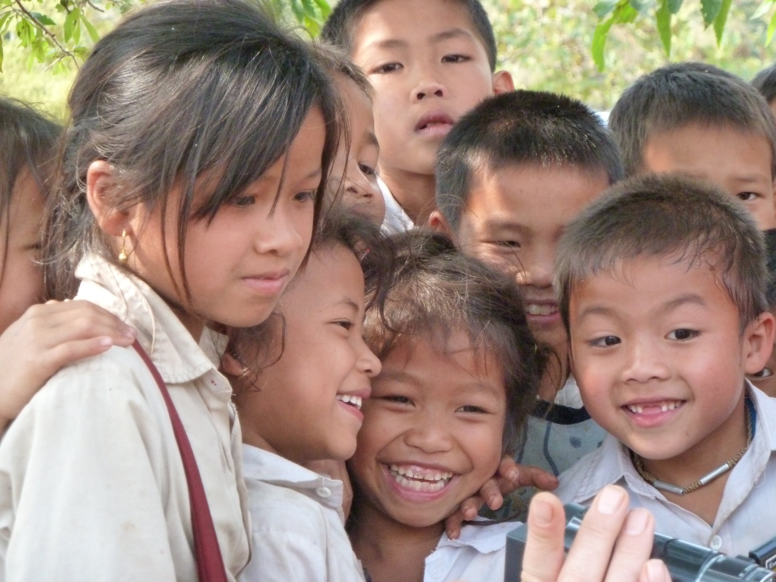 Groupe d'enfants souriants prenant un selfie à l'extérieur.