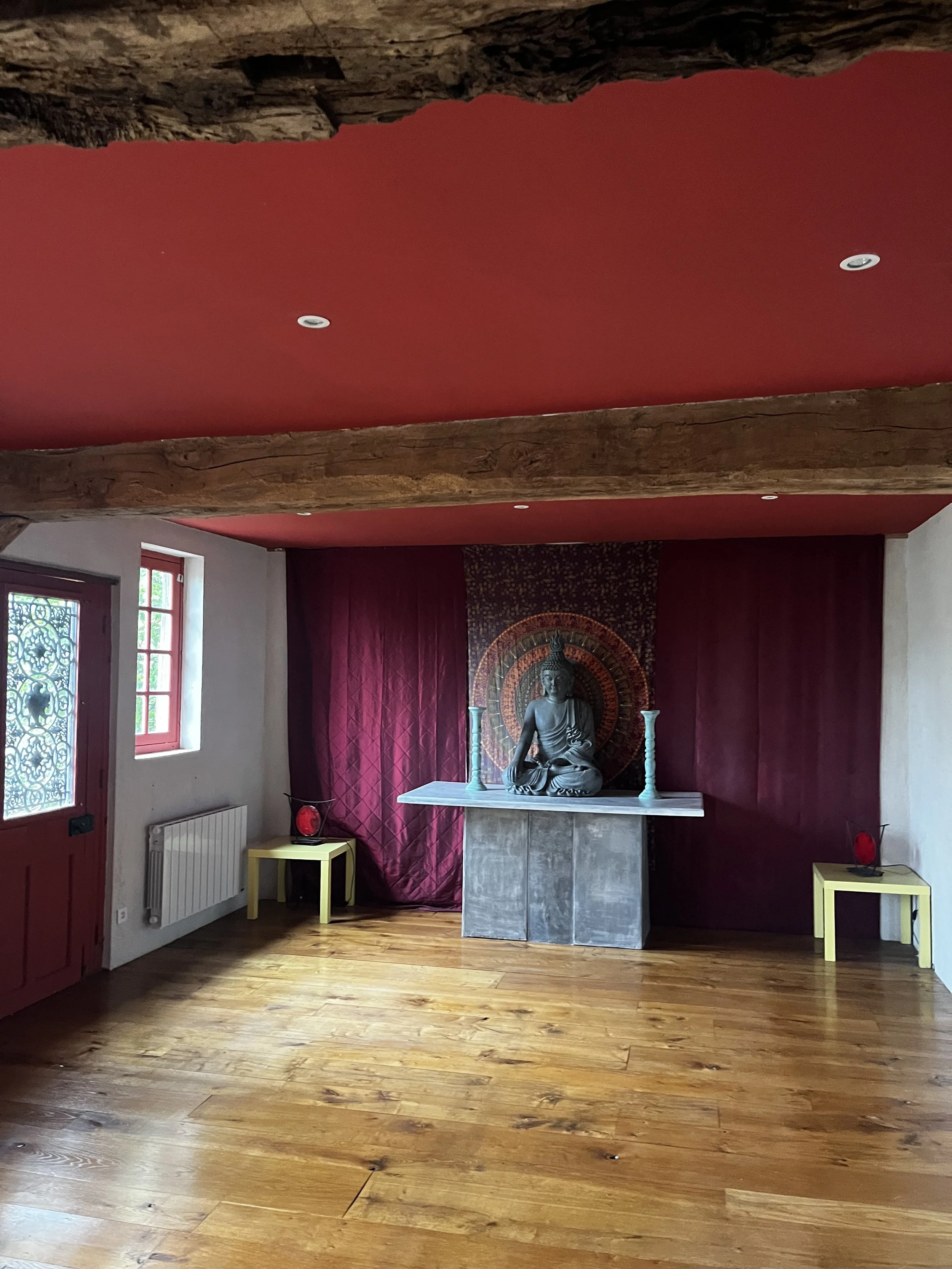 Une salle de pratique dans un gite pour une retraite avec une statue de Bouddha en position de méditation