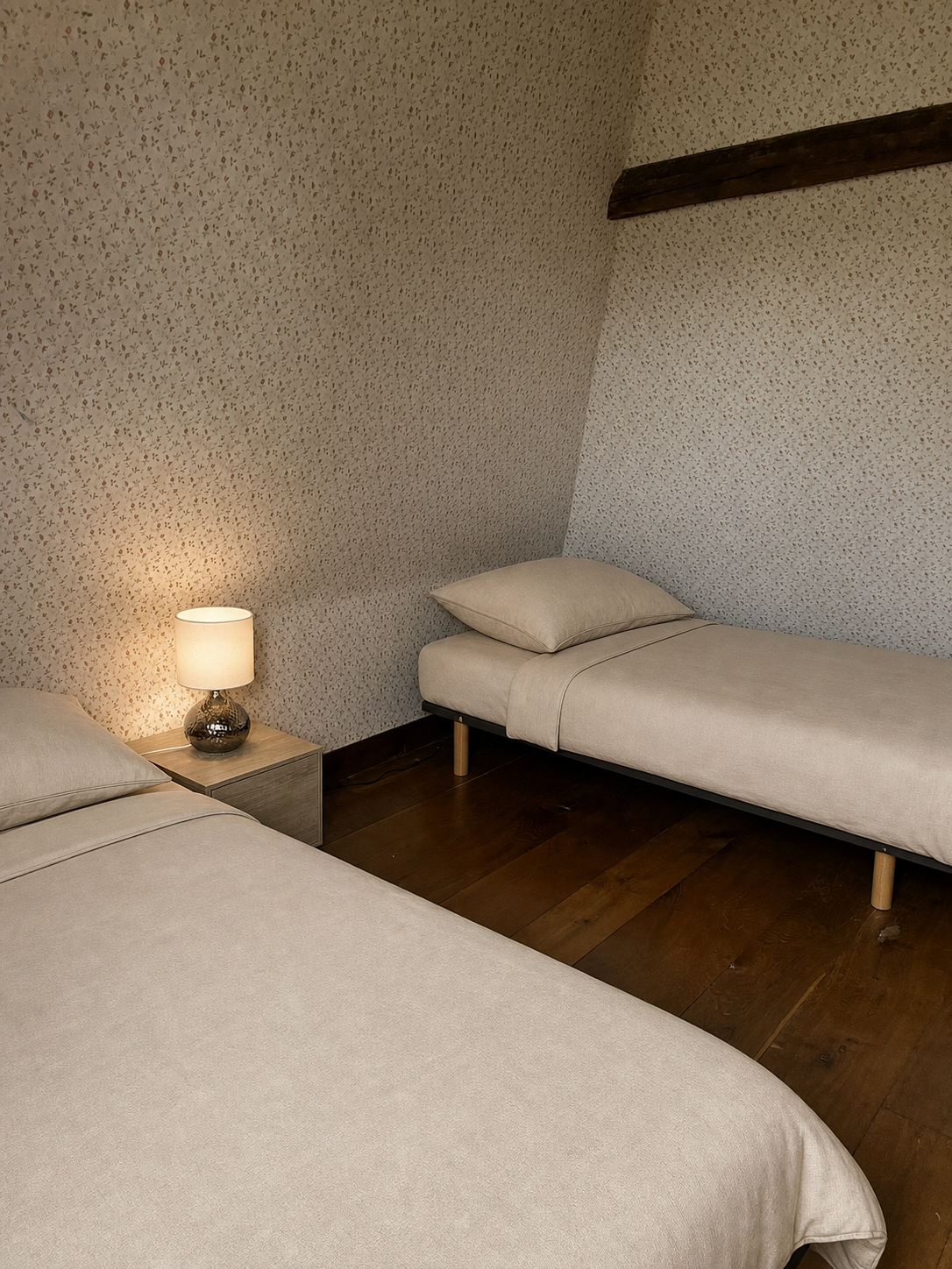 Chambre avec deux lits simples, poutre en bois apparente, sol en bois, gite en normandie pour une retraite en septembre 2026