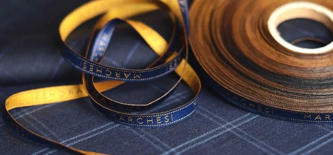 Spools of fabric and measuring tapes on a fabric surface.