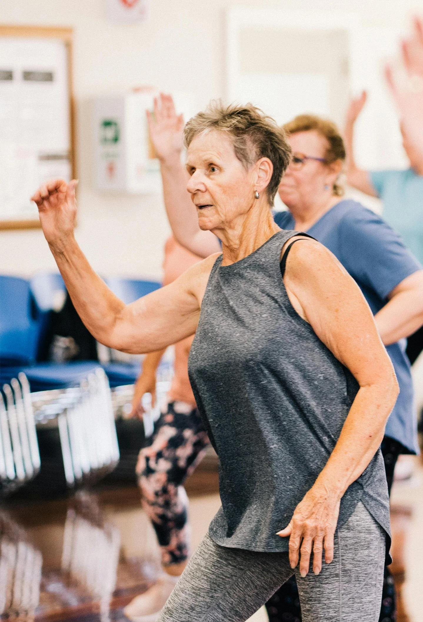 Senior woman participating in a group fitness exercise class for balance and strength training