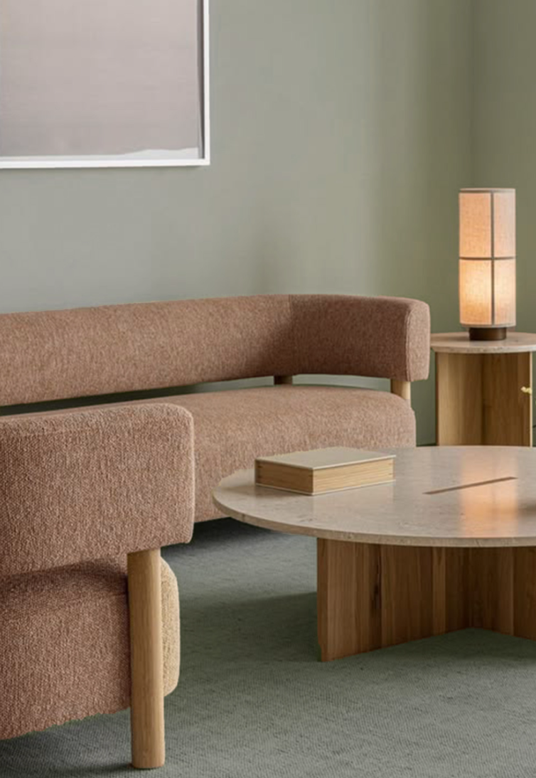 Living room with a pink textured sofa, wooden coffee table, side table, and a tall warm-colored lamp