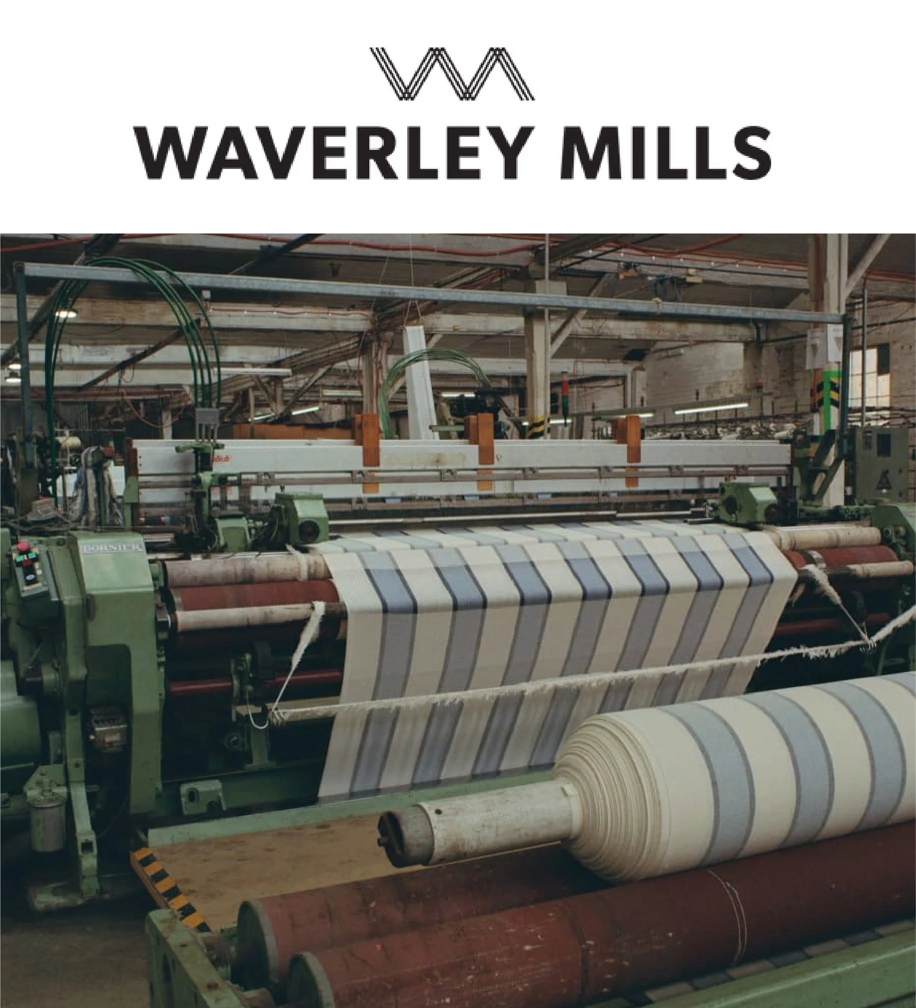 Industrial factory interior with machinery and large rolls of fabric or material.