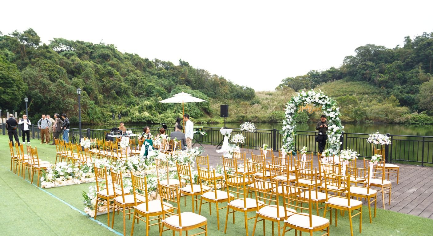 一个优雅的婚礼场地，以一个平静的湖的全景为特色，环绕着美丽的自然风光。