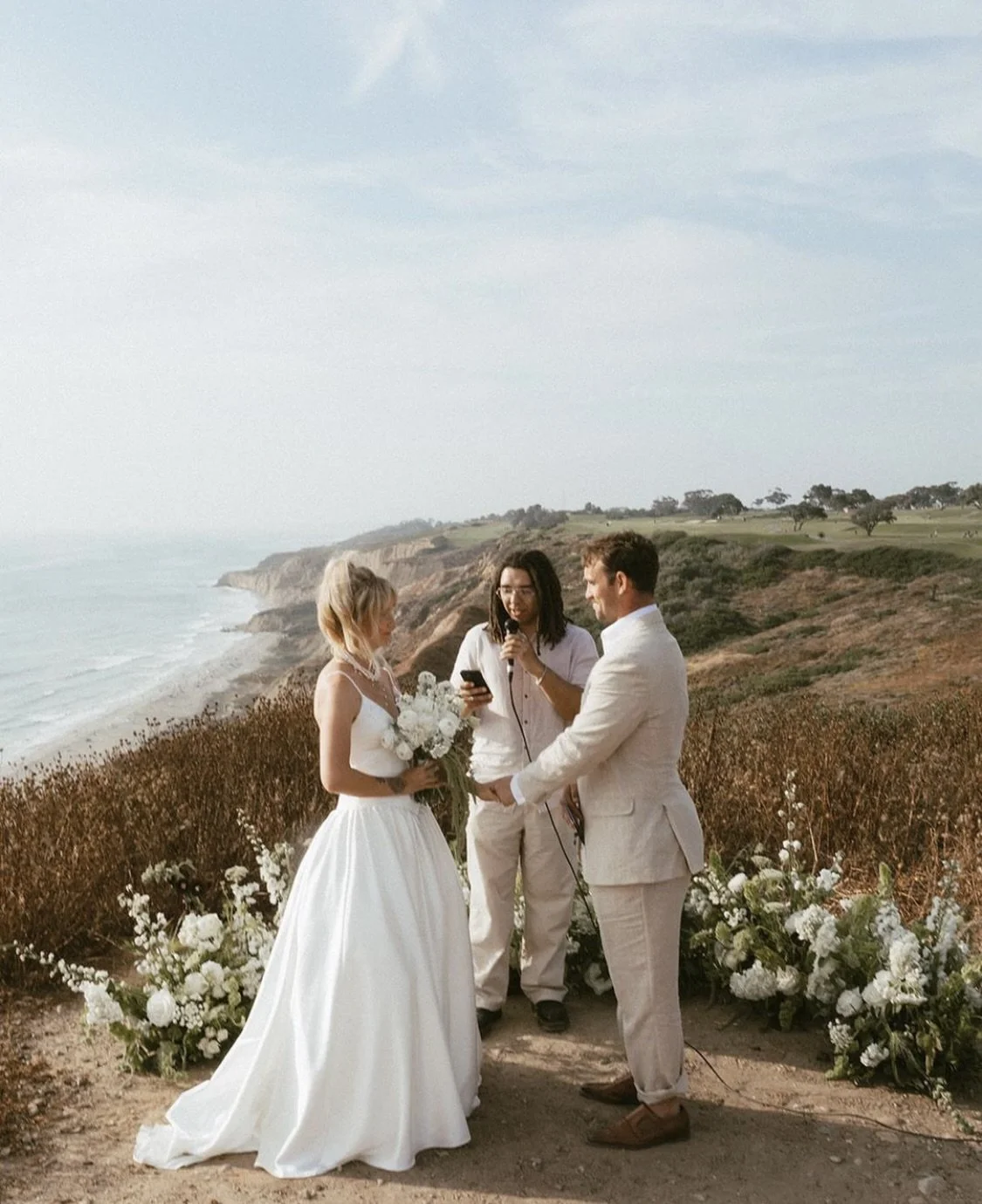 a couple exchanging vows overlooking the ocean for a wedding planned by jasper and lane events