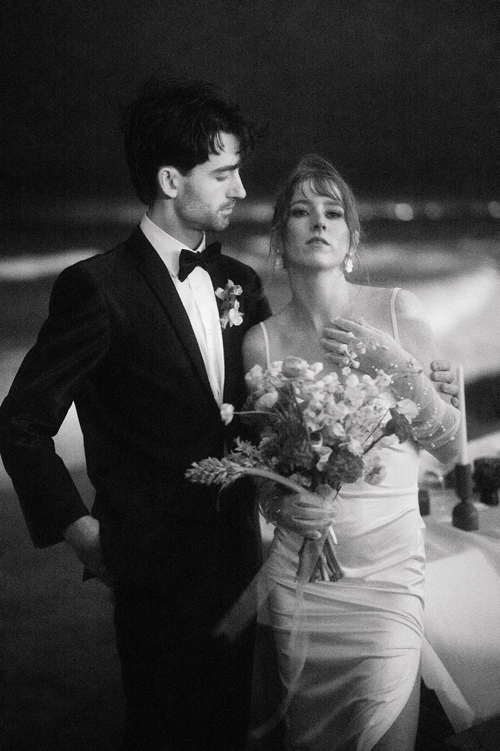 an editorial portrait of Jasper and Lane couple at their wedding reception with an ocean behind them