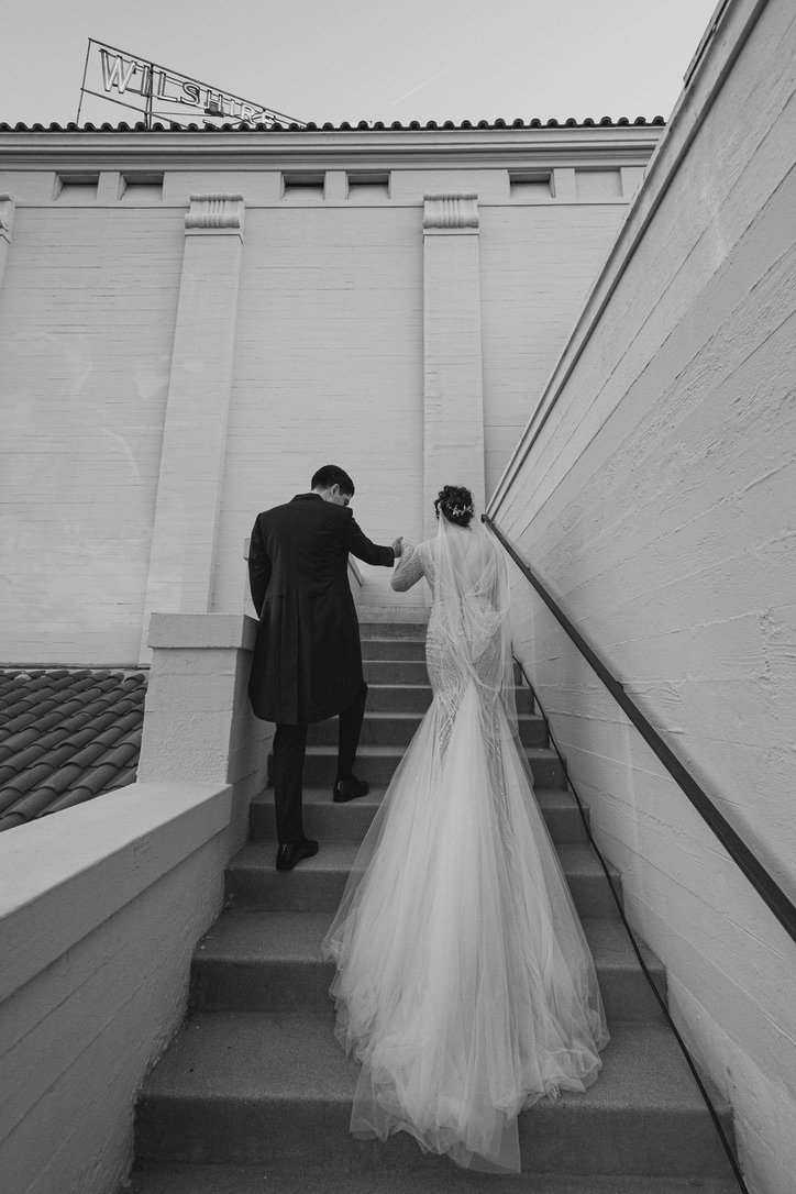 a bride and groom walking up the stairs at the Ebell of Los Angeles