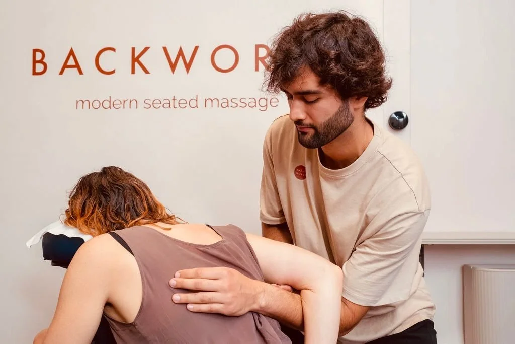 Massage therapist undertaking a massage and stretches. Client is fully clothed.