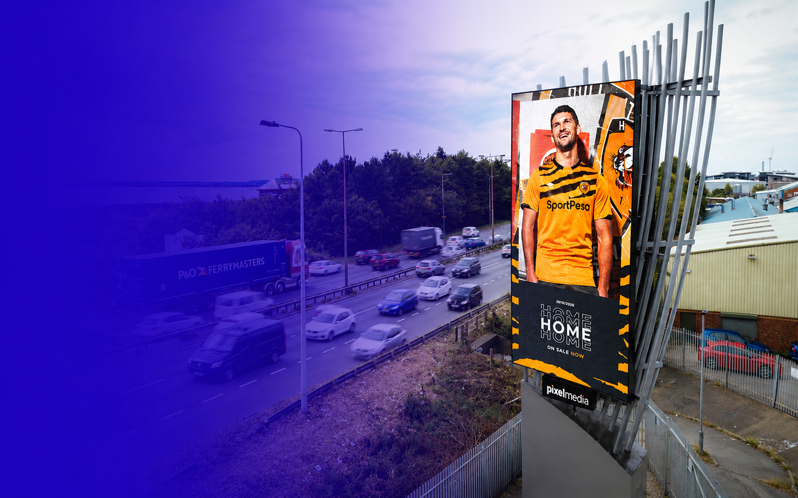 Large digital billboard displaying a man in a yellow and black sports jersey with a tiger and logo in the background, next to a busy road with cars and trucks, under a partly cloudy sky.