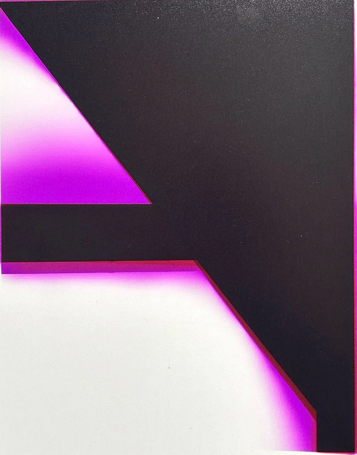 Close-up of a modern electronic device with black, purple, and pink geometric design and glowing backlight.