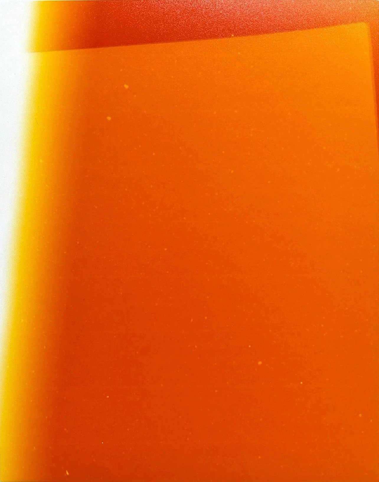 Close-up of a red-orange surface with a gradient yellow-orange edge on the left side.