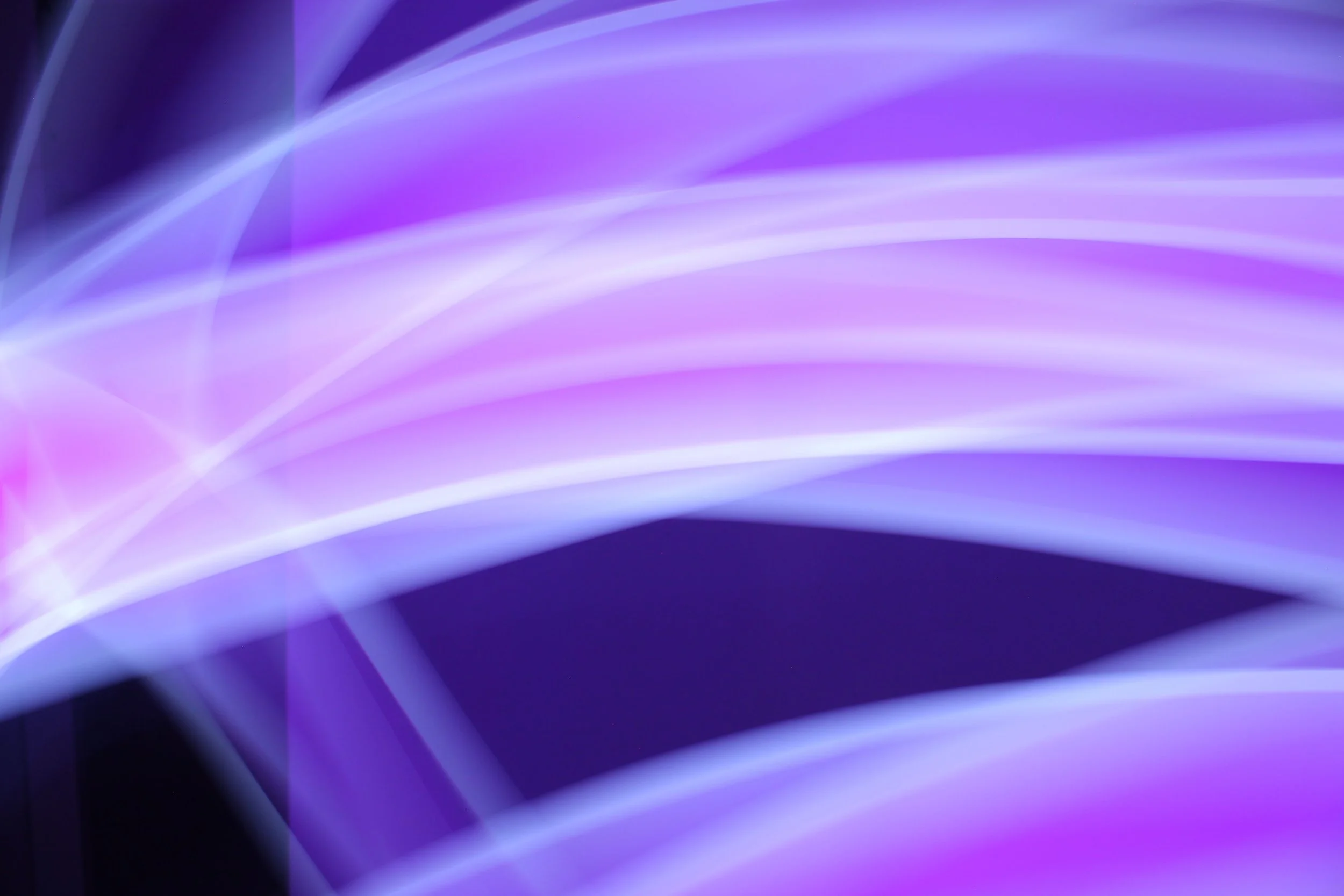 Abstract background with flowing purple, blue, and white light streaks.