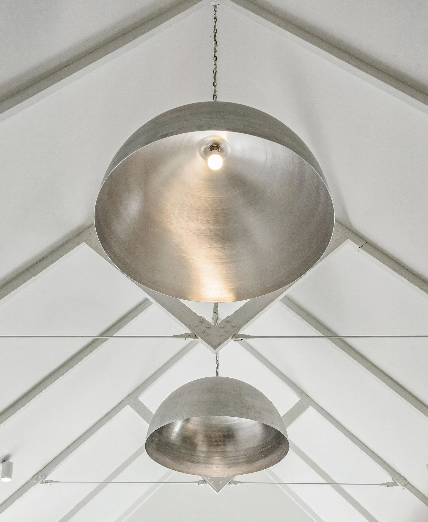 Raw aluminium pendant lights suspended in perfect symmetry, celebrating scale and proportion 💡
