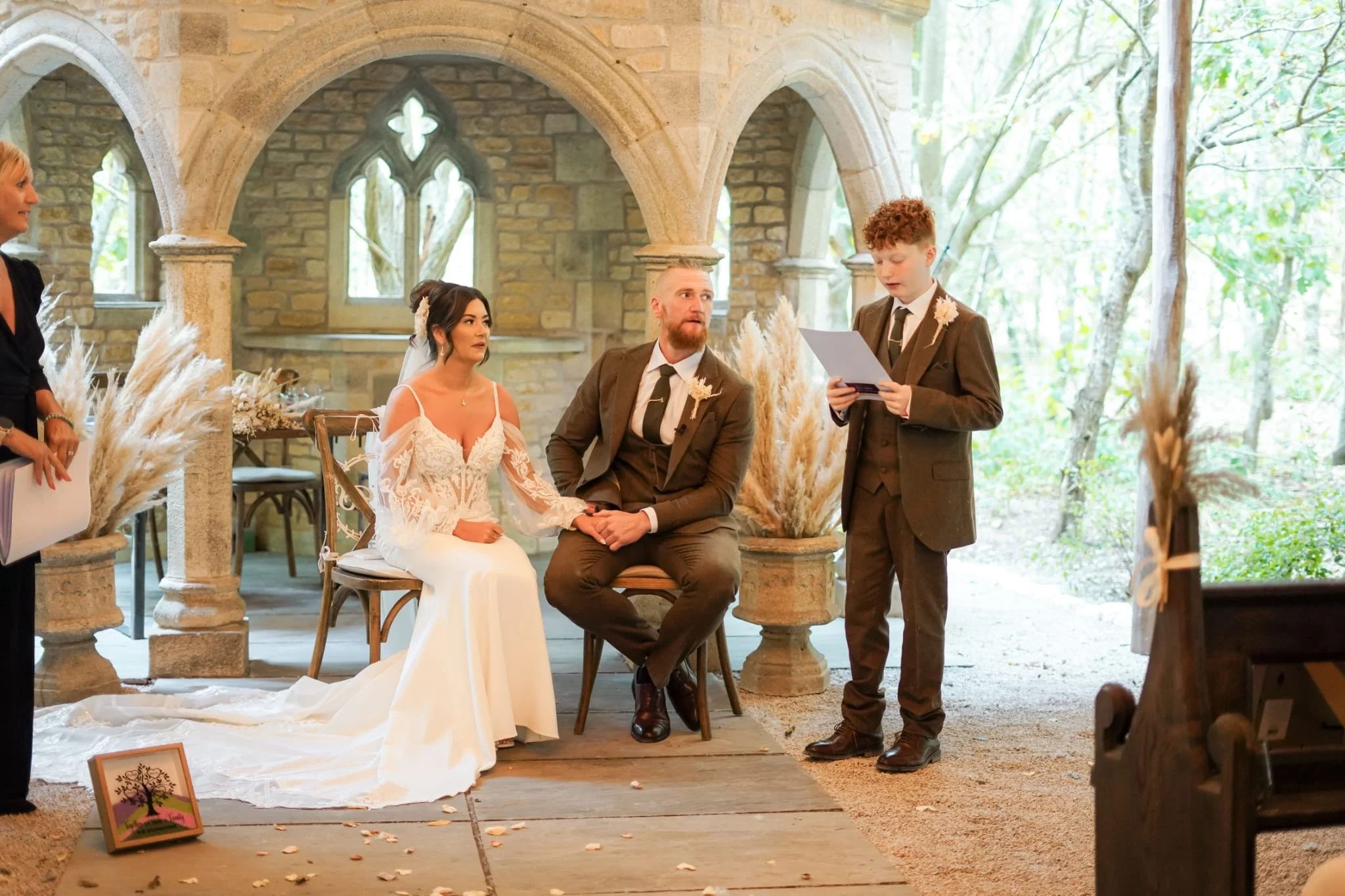 Bride and groom listening to their son’s wedding reading at an elegant church-style venue in Spain