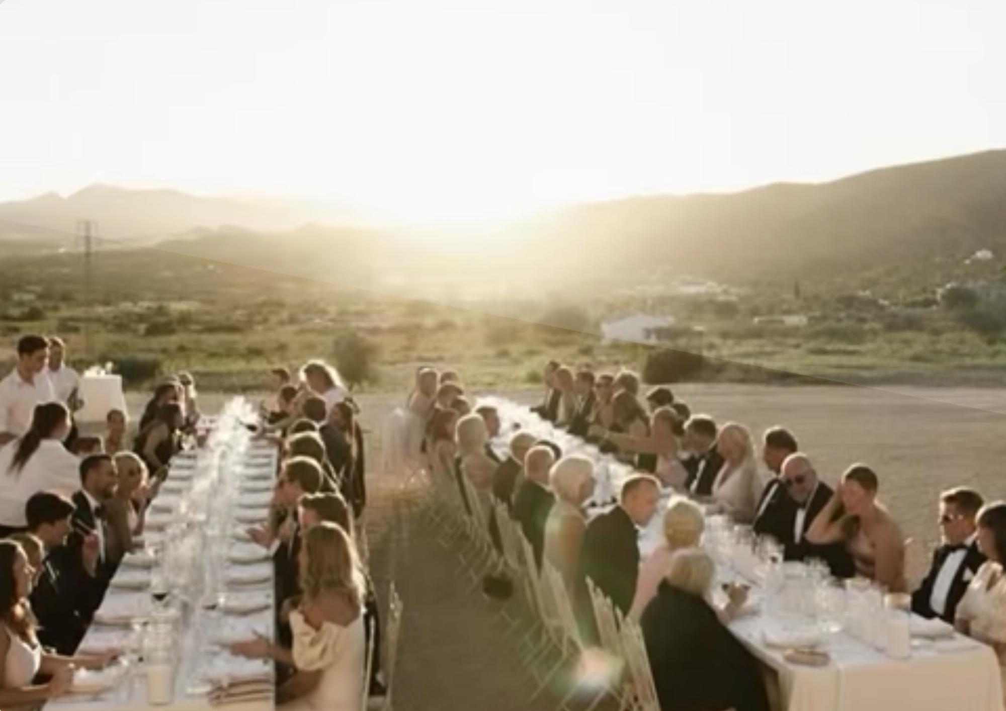 Outdoor vineyard wedding reception at sunset near Gata de Gorgos with long banqueting tables with mountain views