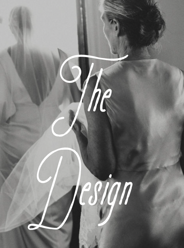 Black-and-white photo of a woman in satin robe looking in a mirror, with the text 'The Design' overlayed.
