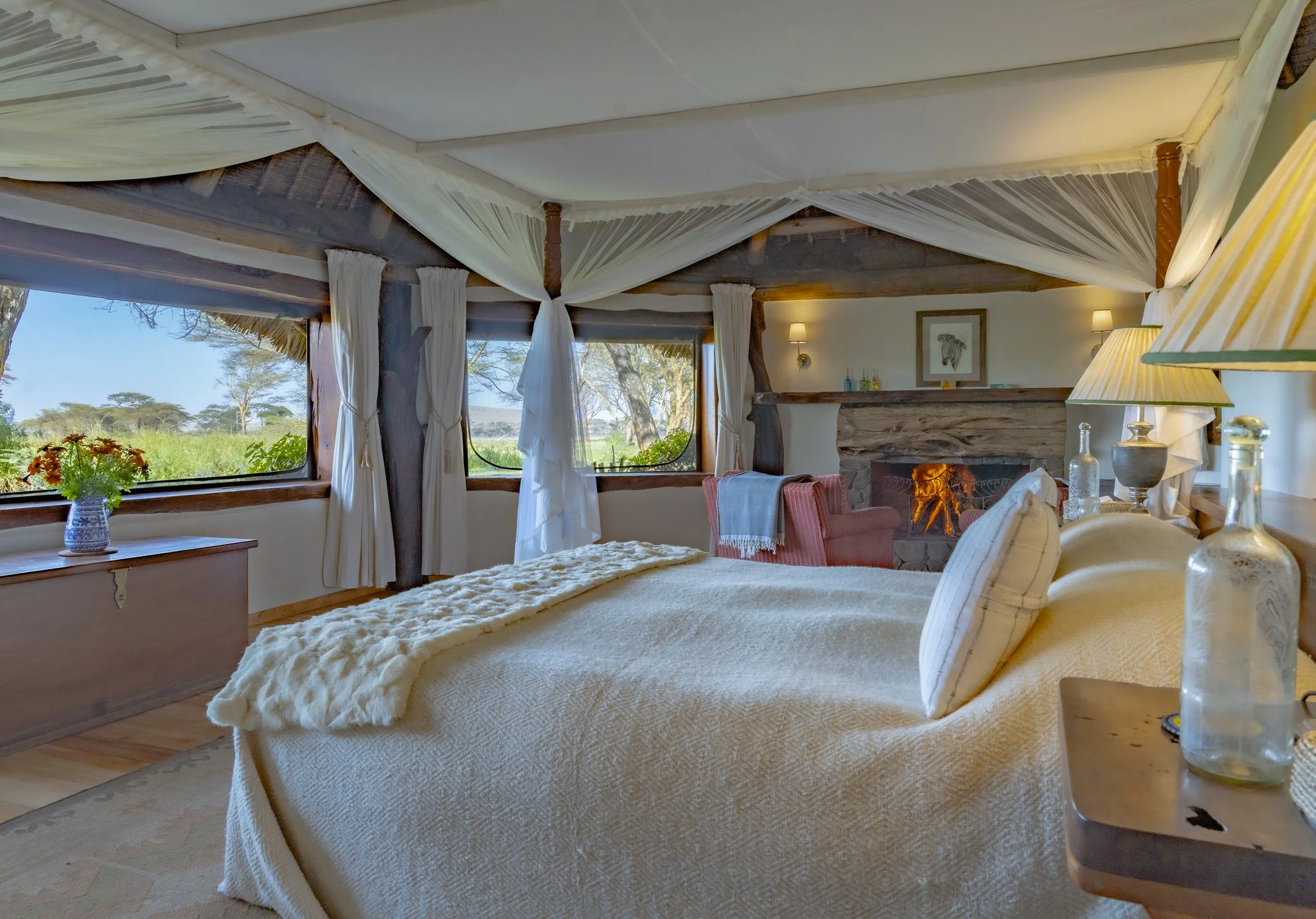 Luxury tented bedroom with four-poster bed and fireplace overlooking the plains, Sirikoi Cottage, Laikipia, Kenya