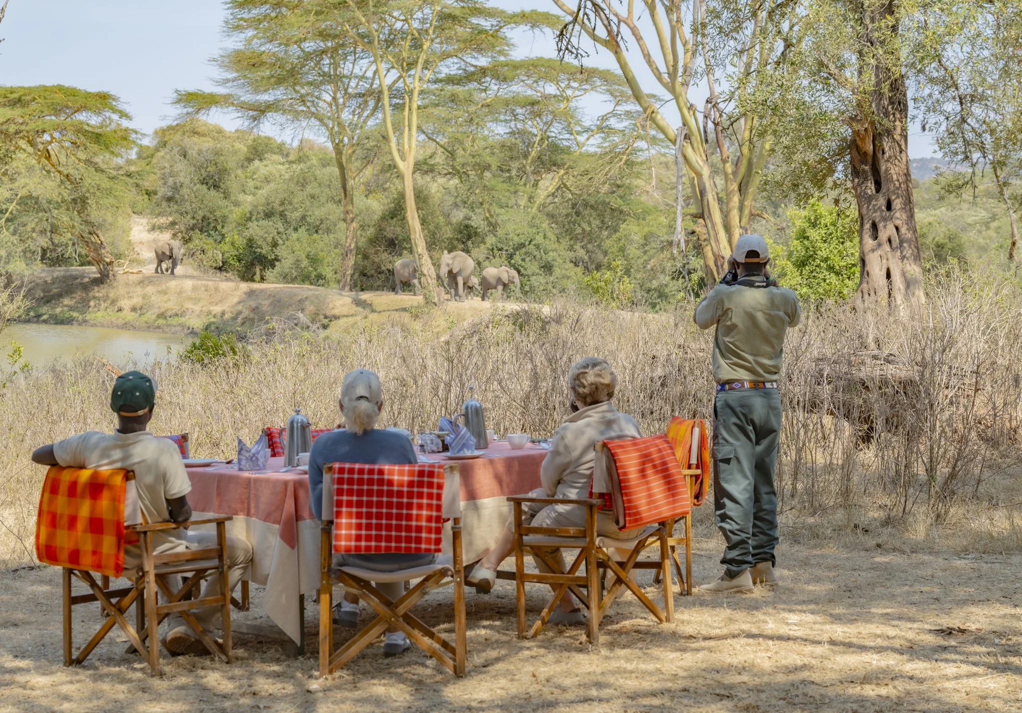 Elephants in the background with guests enjoying bush breakfast on Borana Conservancy