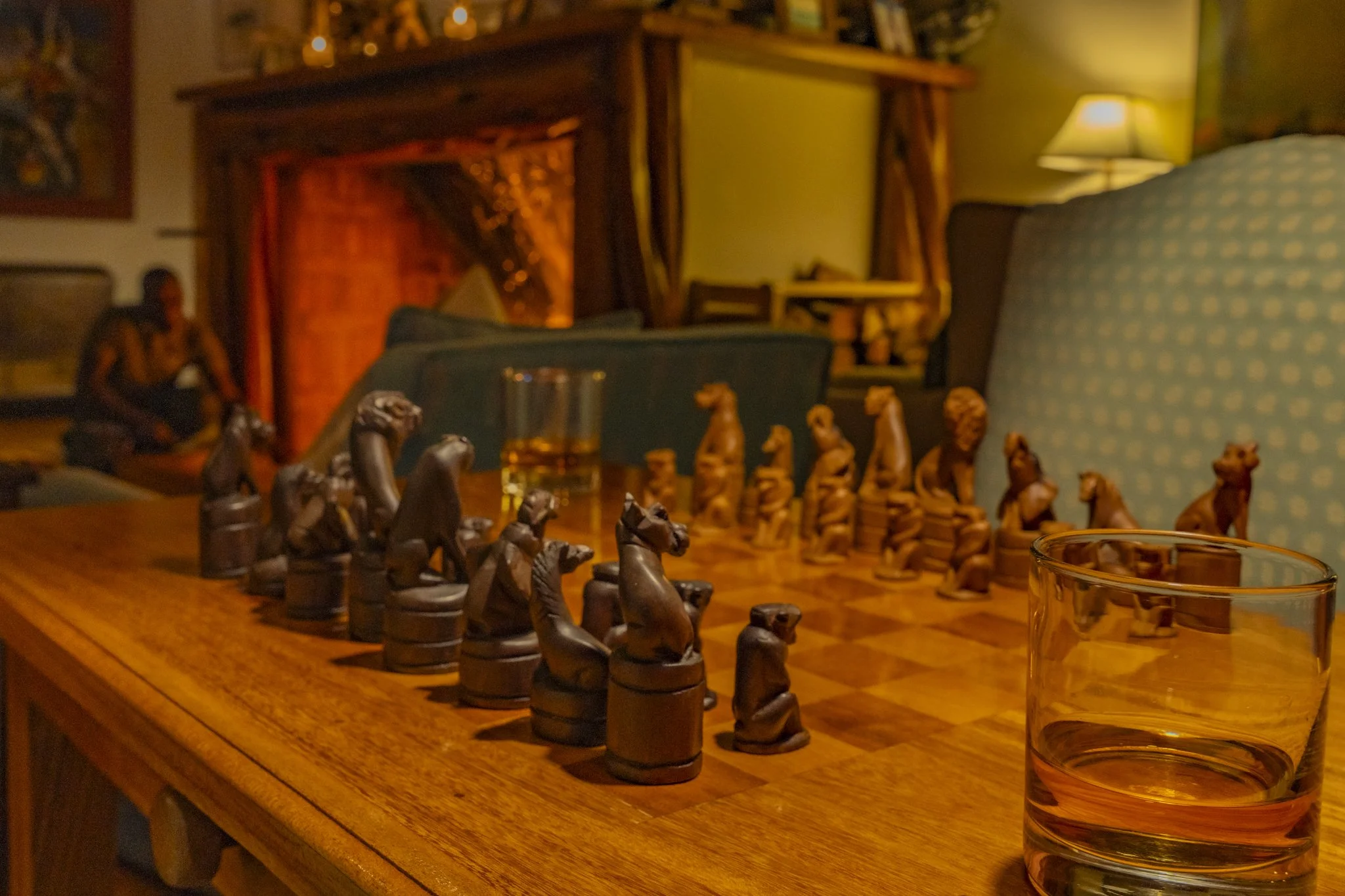Night game of chess with whisky glasses and fire in the background