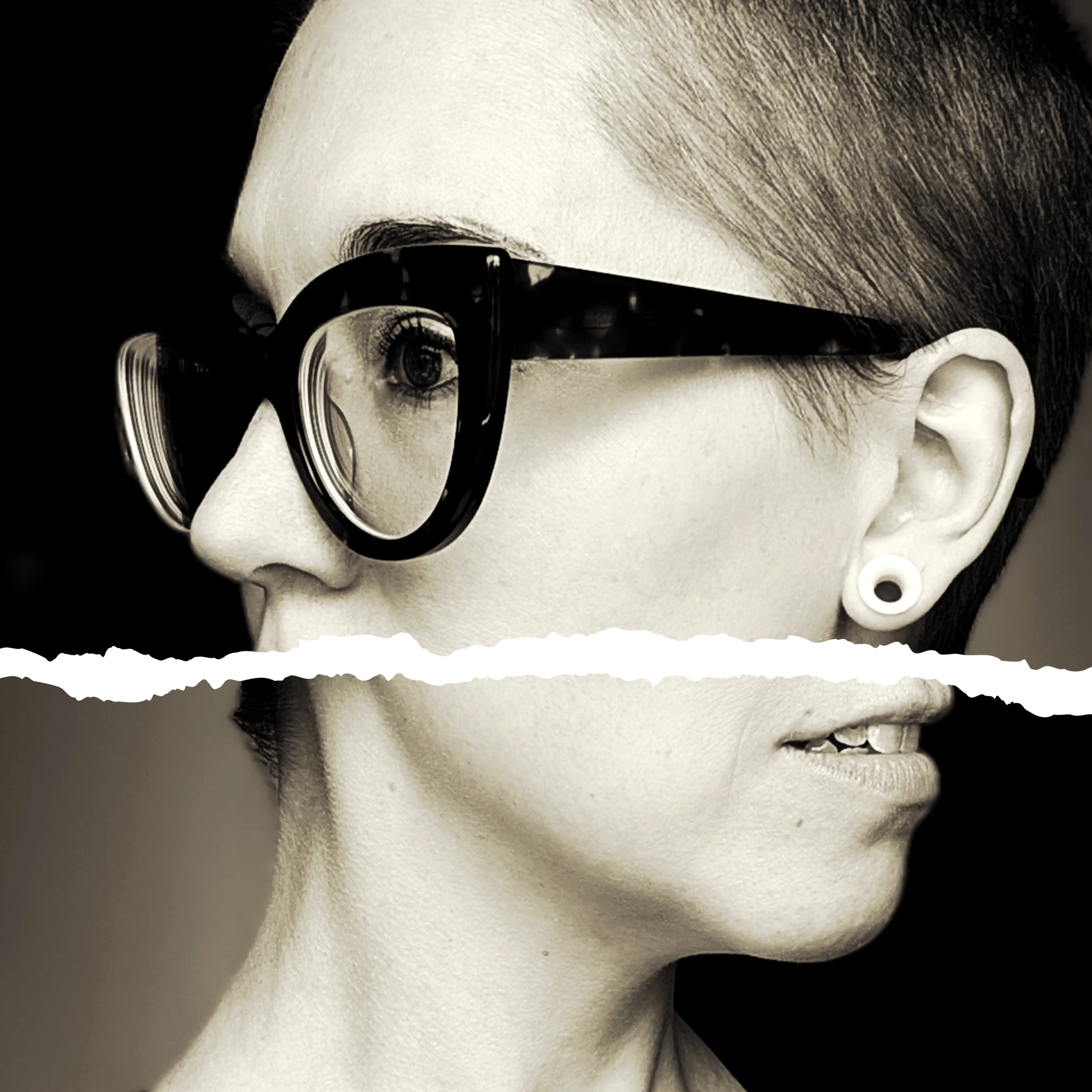 Close-up of the shop owner's face with short hair, wearing black glasses, showing eye, nose, and part of mouth, against a black background.