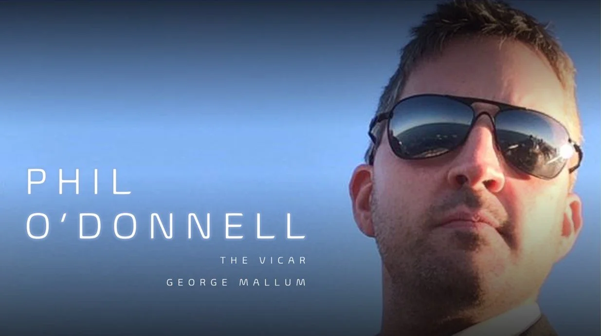 Close-up of a man wearing sunglasses, with text overlay saying 'Phil O'Donnell, The Vicar, George Mallum' against a blue sky background.