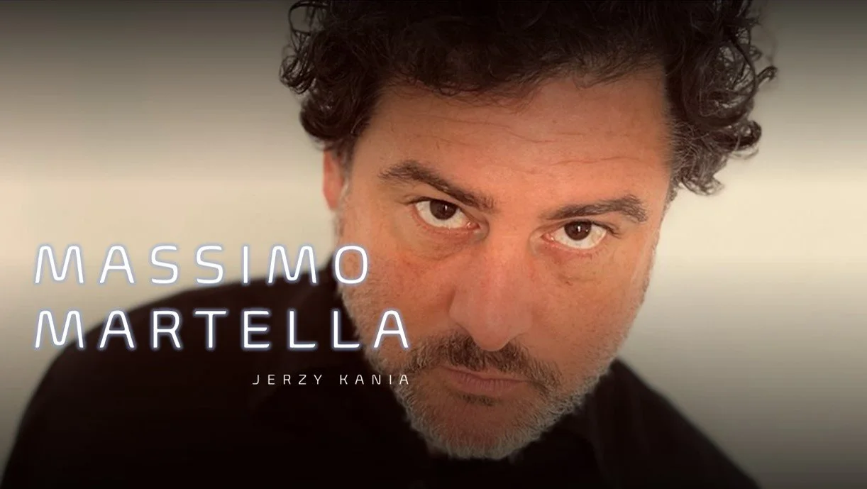 A man with curly dark hair and a beard looking into the camera, with text overlay reading "Massimo Martella" and "Jerzy Kania".