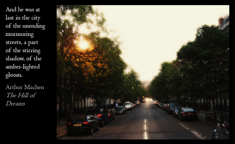 A city street at sunset with parked cars lining both sides and trees on the sidewalk. The sky is partly cloudy with the sun visible behind the trees. On the left side, there is a black section with white text from Arthur Machen's 'The Hill of Dreams' describing the shadowy, amber-lit gloom of the city.