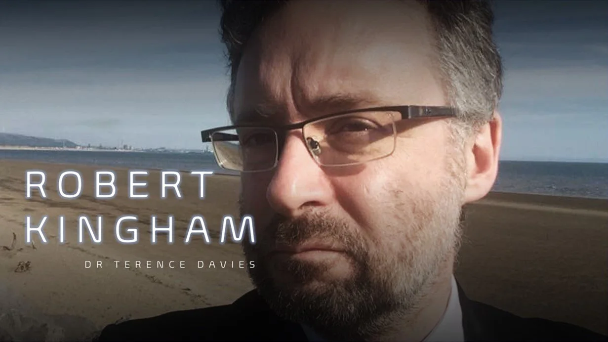 Close-up of a middle-aged man with glasses and a beard on a beach, with text overlay that reads "Robert Kingham" and "Dr Terence Davies".